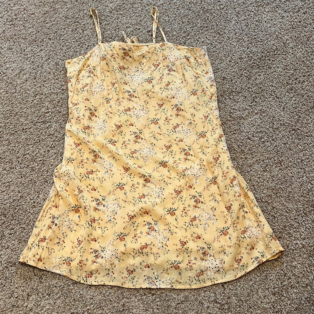 Yellow dress with red orange flowers and green leafing, bow tied, and zipper